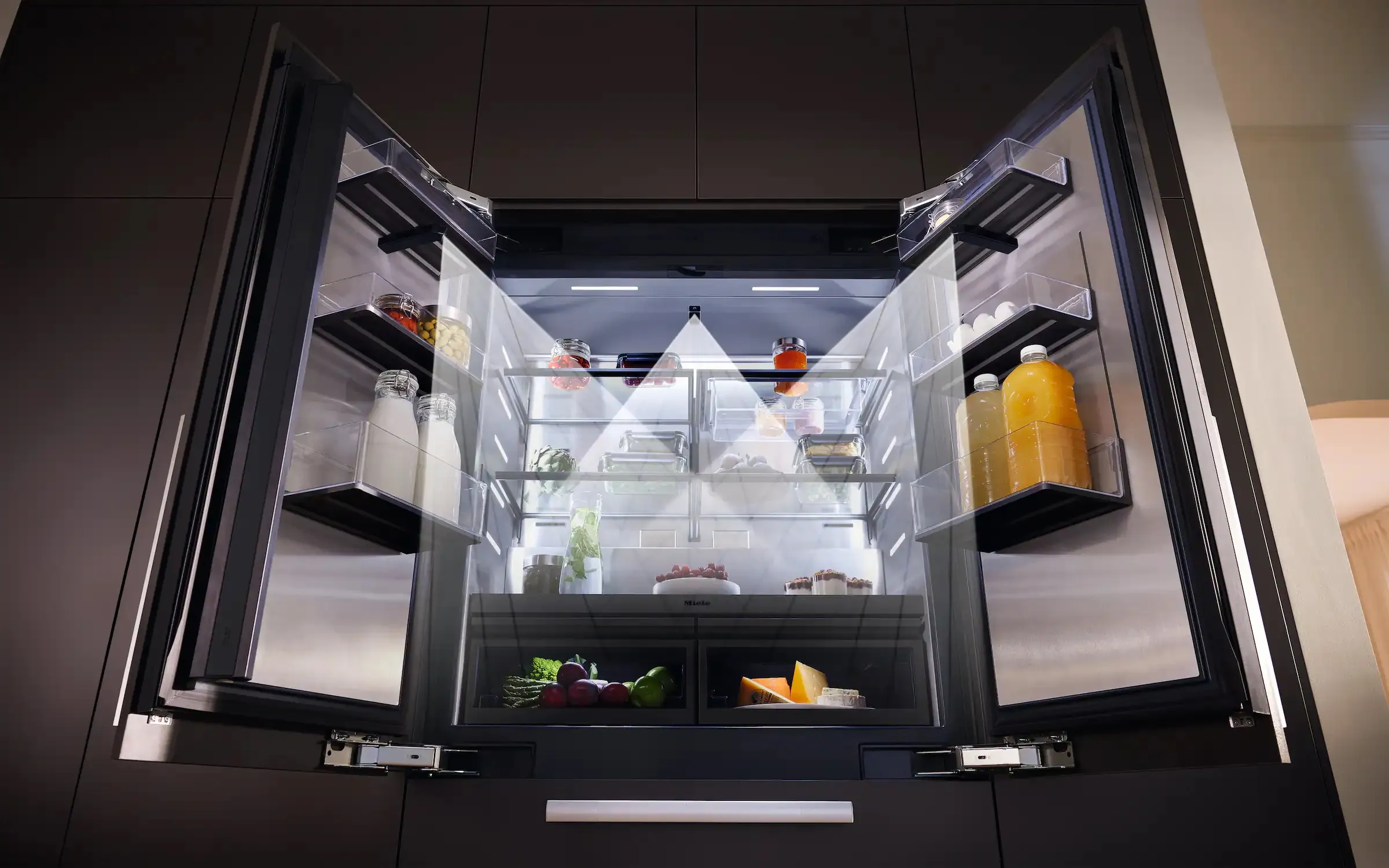 Open Miele MasterCool refrigerator showing interior shelving and stocked compartments